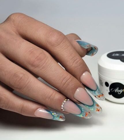 Combination of turquoise and clear French tips with glitters and floral nail designs on super long round nails