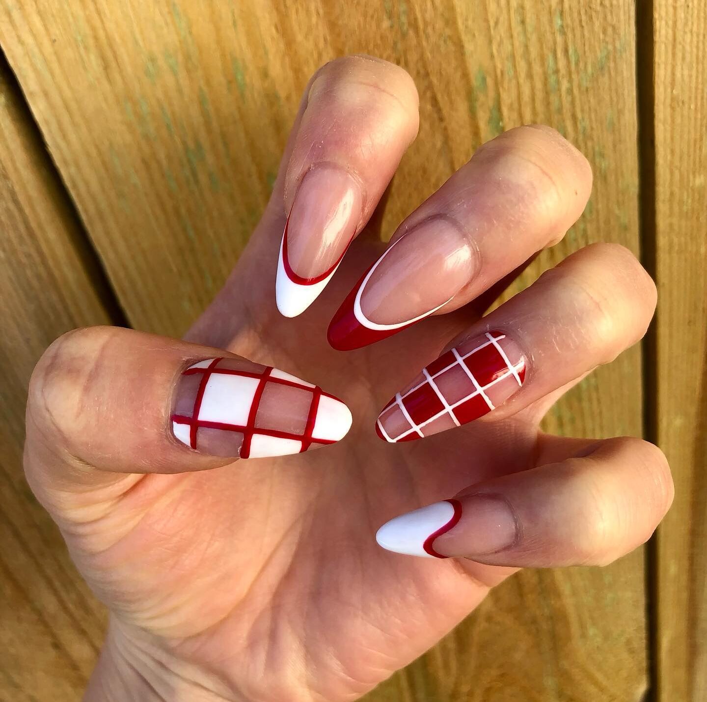 Red and white French tips and checkered nail art on long almond nails