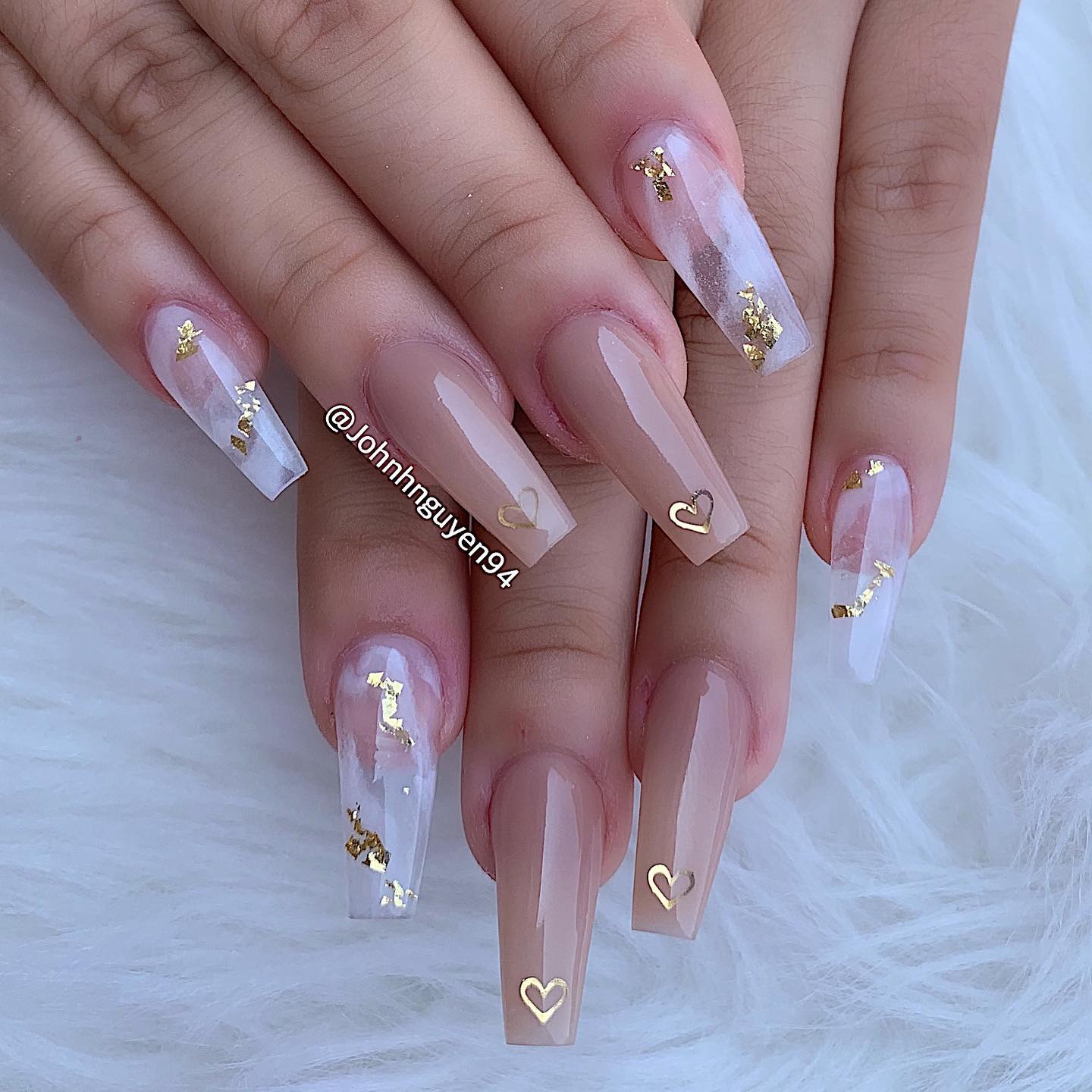 Nude nail color and clear marble nail design with gold foil and gold hearts on long coffin nails