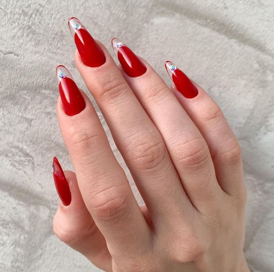 Vibrant red nail color with clear French tips and rhinestones nail designs