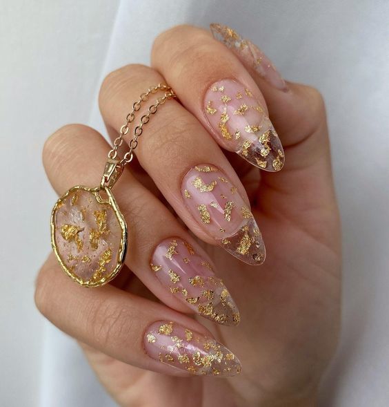 Long almond shaped clear nails with gold foil accents