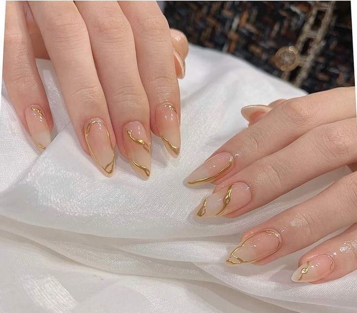 Clear almond nails with chrome gold swirls