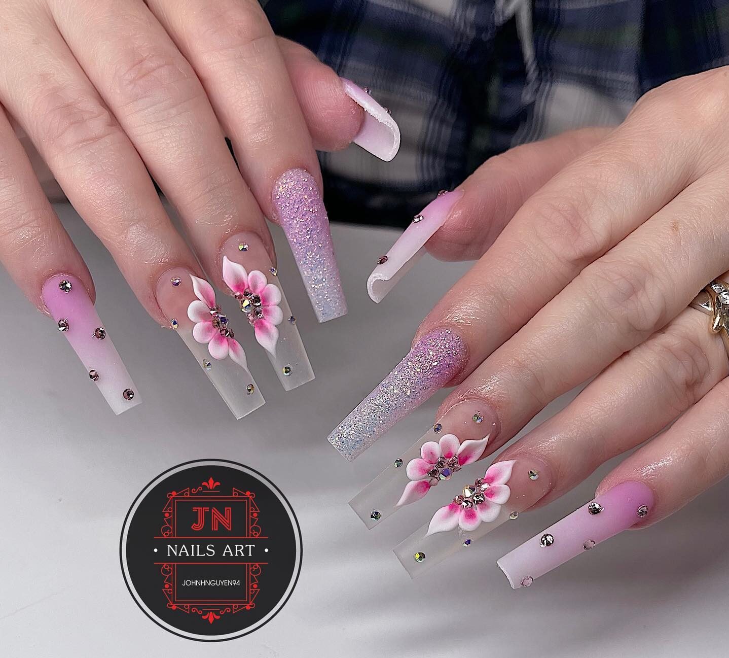 Light pink ombre effect with glitters, rhinestones, and 3D floral nail arts on super long coffin shaped clear nails