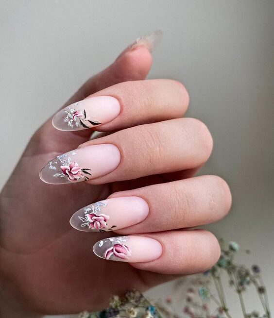 Matte blush pink nail color with clear French tips and floral nail arts on long round nails