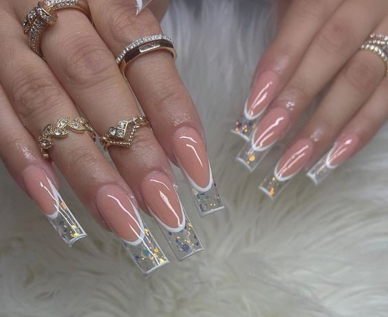 Long square shaped nude nails with clear French tips and glitters