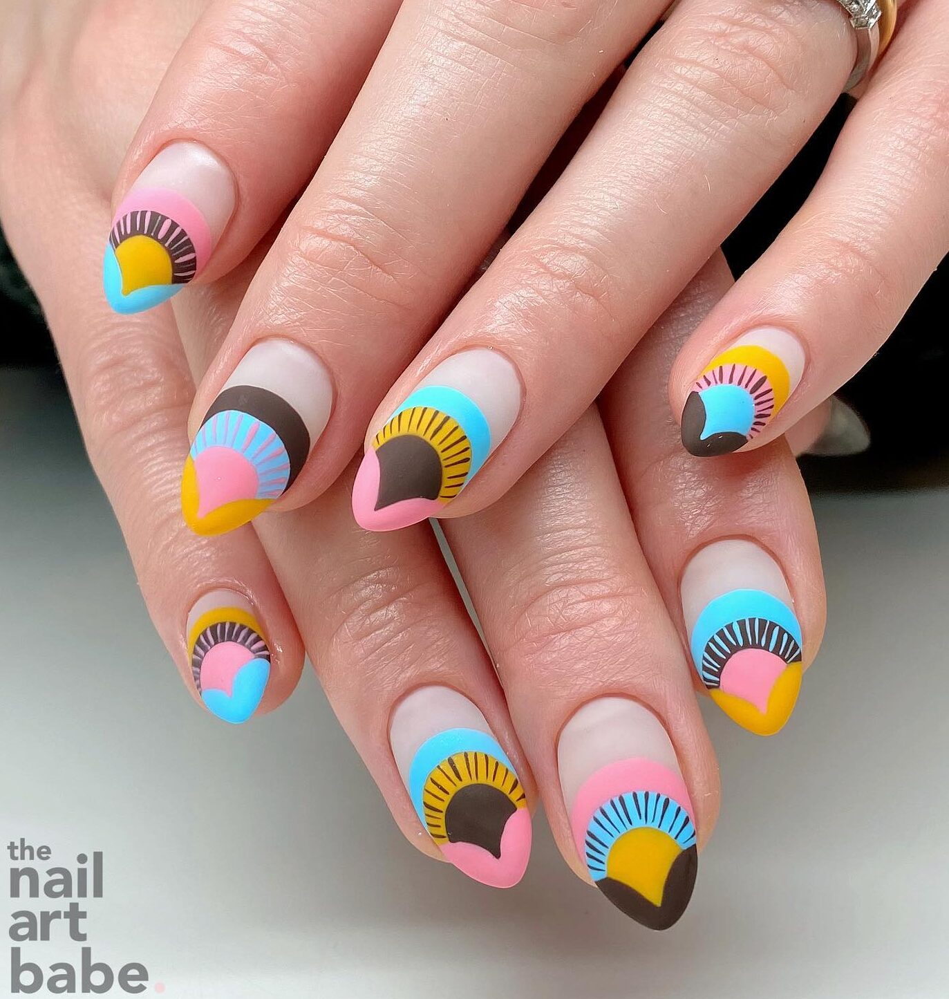 Matte finish multicolored geometric pattern on medium almond nails