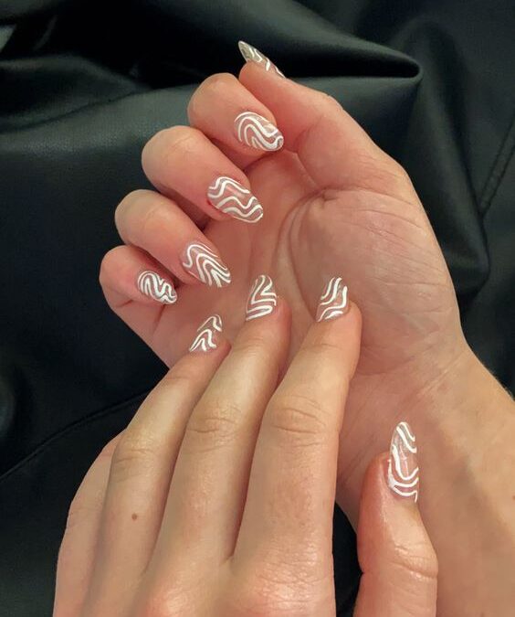 Clear round nails with white swirling patterns