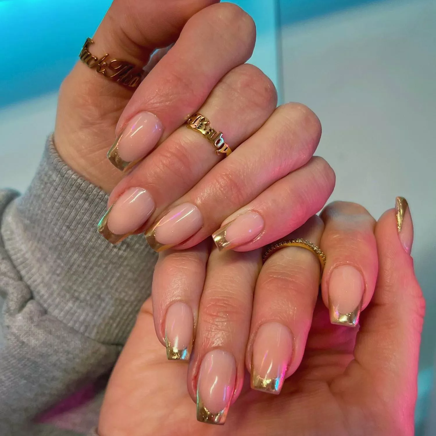 Manicure with gold French tips and gold graphic rings