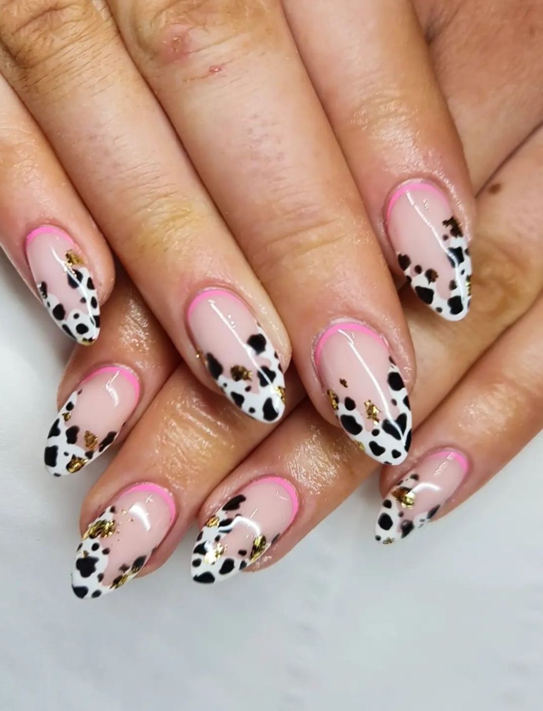 Cow print French tip nails with a touch of pink.