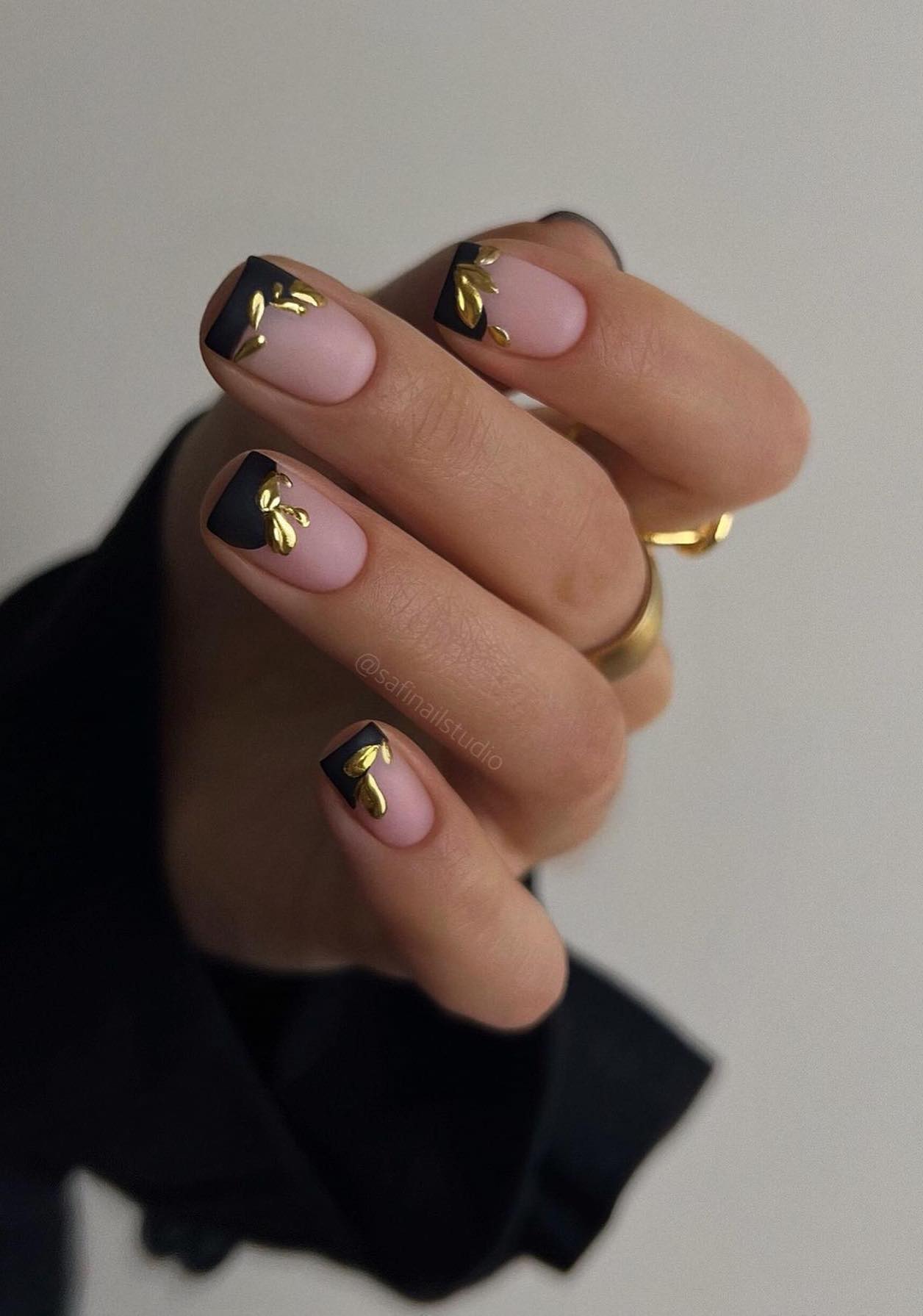 Short matte black and gold nails.