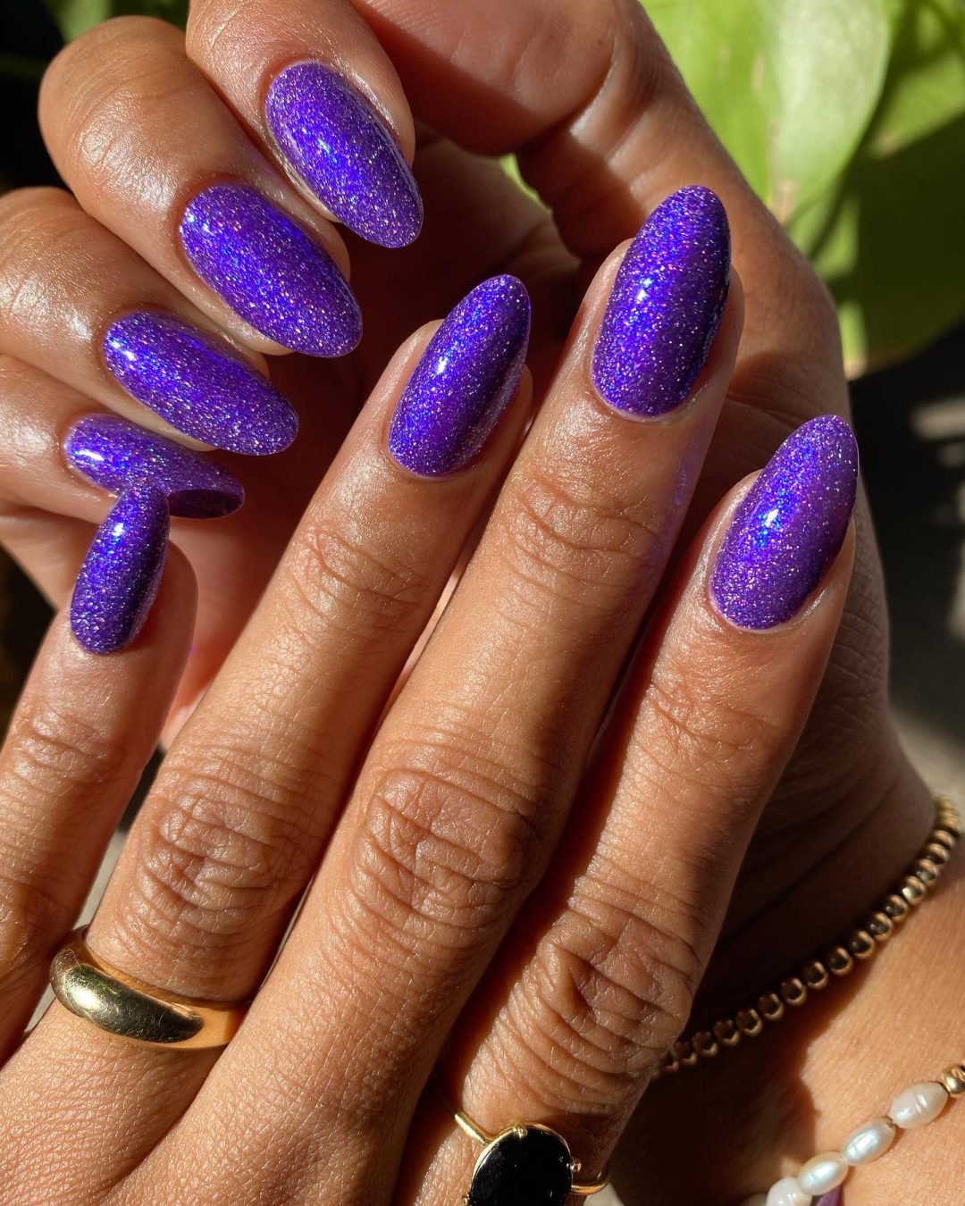 Long dark purple nails with glitter.