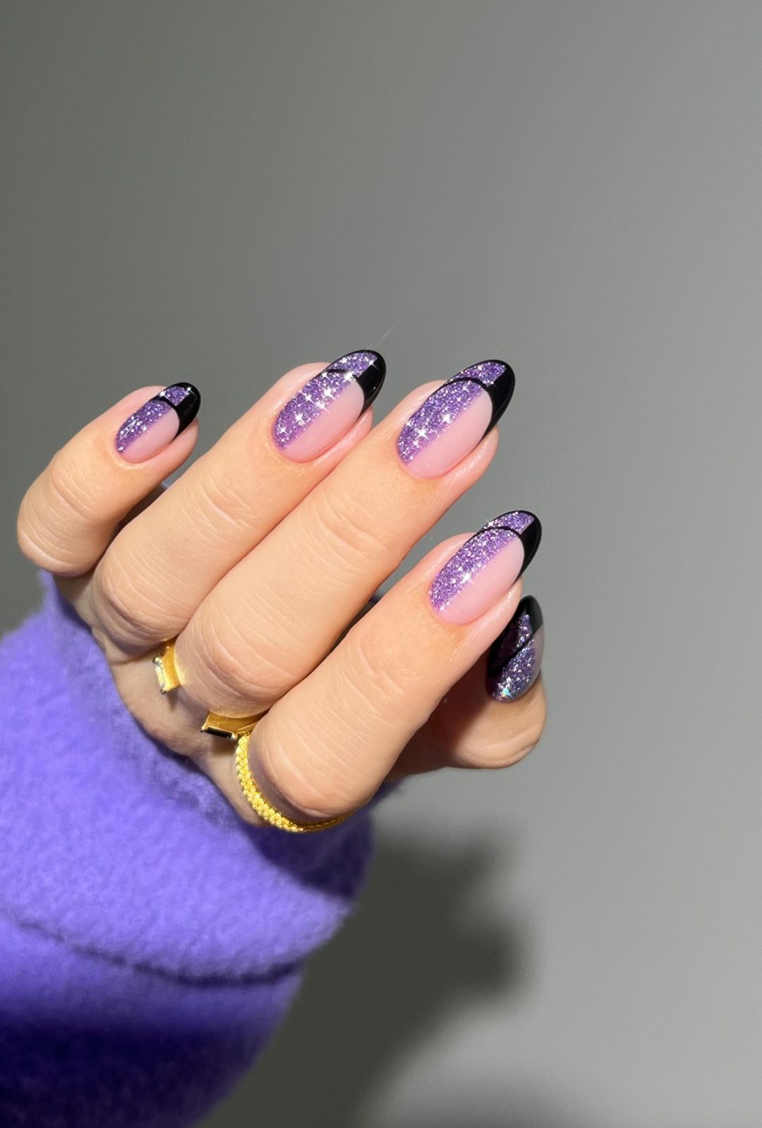 Black French tip nails with purple glitter.