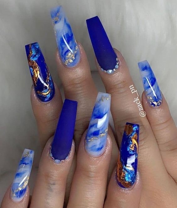 Royal blue nail polish with marble nail art and gold foil on long coffin nails