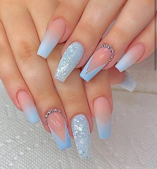Light blue long coffin nails with ombre nail art, French tips, stones, and glitters
