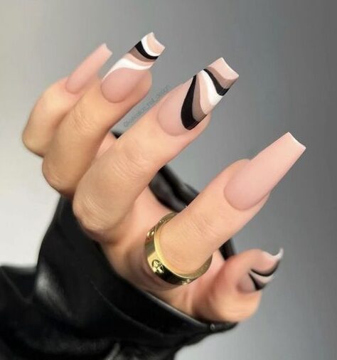 Matte finish beige shade with neutral colors swirls on long coffin nails