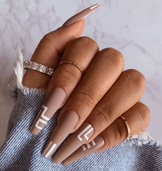 Light brown shade in matte finish with white abstract design on long coffin nails