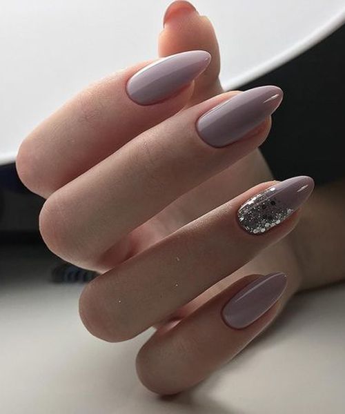 Glossy neutral color nail polish with silver glitters on medium almond nails