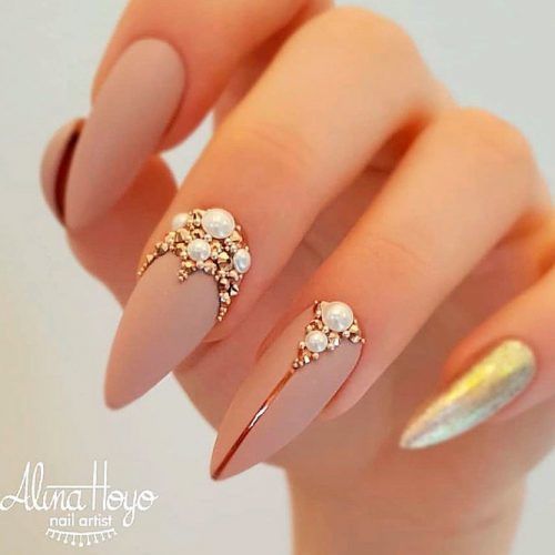 Nude brown nail polish in matte finish with pearls and bling on long stiletto nails