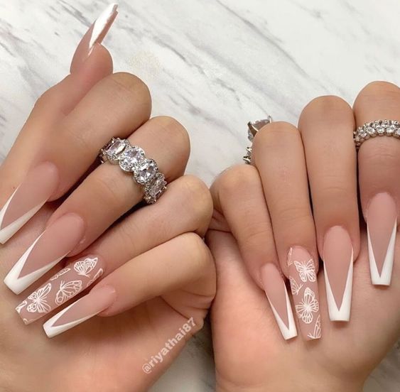 Long acrylic nails with white French tips and white butterflies nail art
