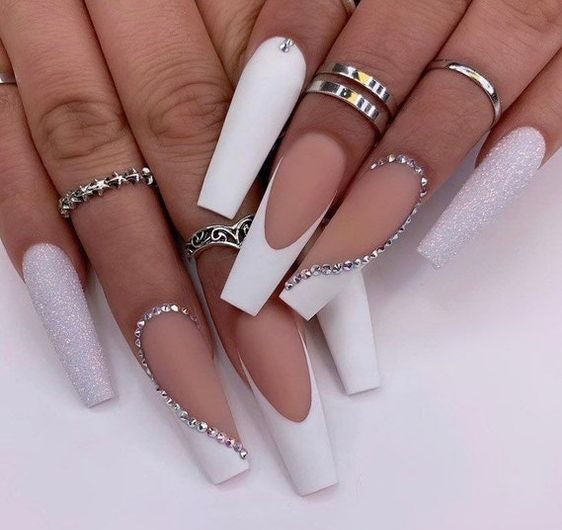 Matte white nail polish with glitters and rhinestones on long coffin nails