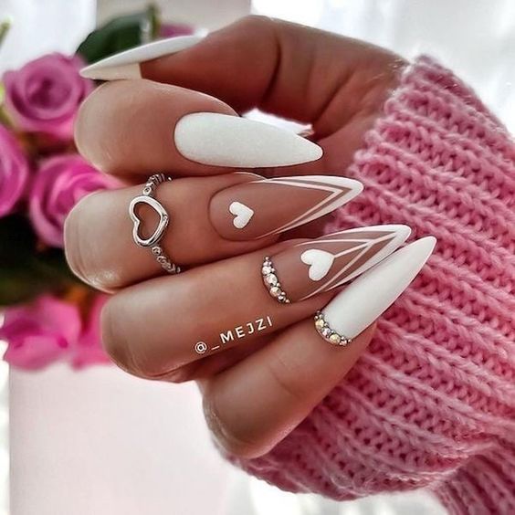 White nail polish with white hearts and white French tips on long stiletto nail