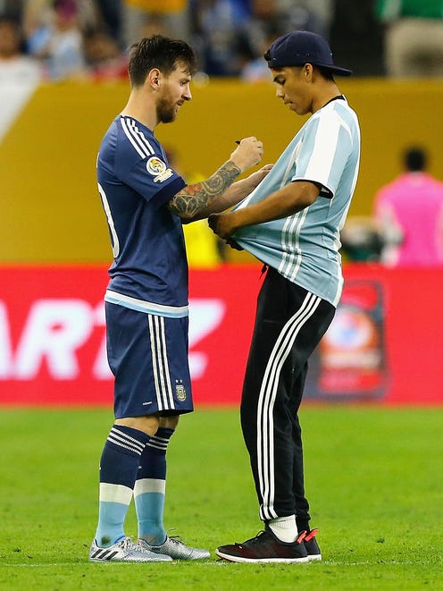 The fan handed Messi a marker, and he proceeded to autograph his shirt.