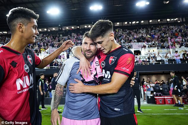 Lionel Messi is embraced by Newell's Old Boys players after a preseason friendly vs. Miami